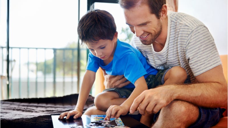 Father and young son do puzzle together