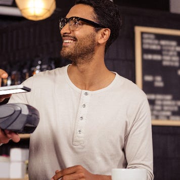 man at coffee shop paying with mobile wallet