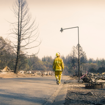Fire fighter walking along a street where every home burned to the ground
