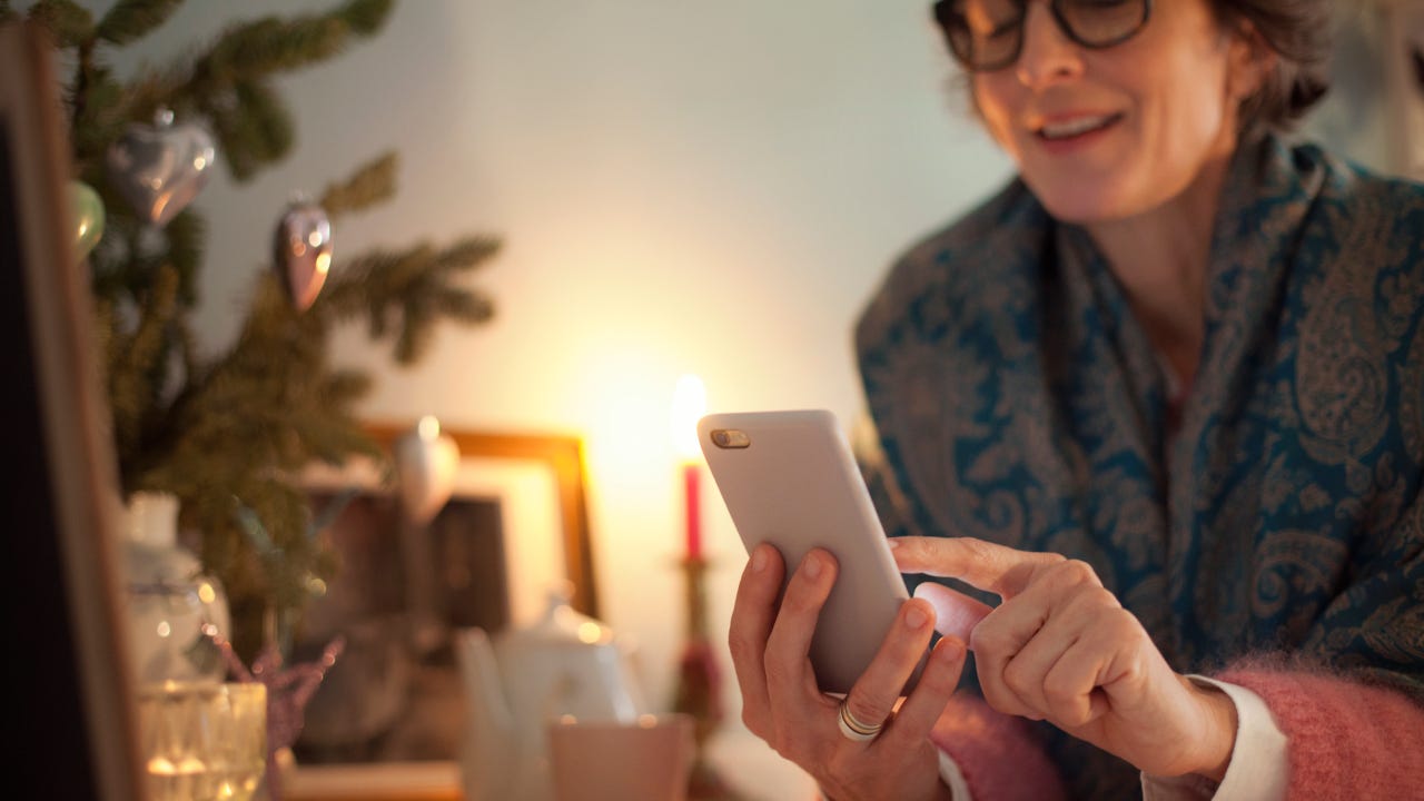 Woman online Christmas shopping using smart phone - stock photo