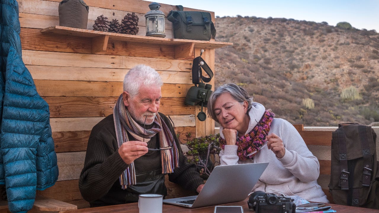 Two older adults research online.
