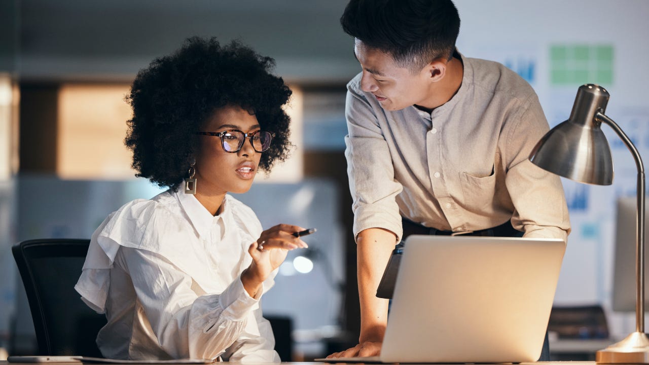 Black woman, businessman or laptop in night office for digital marketing strategy, brand logo design or website ux planning. Talking creative designer, workers or employees working late on technology