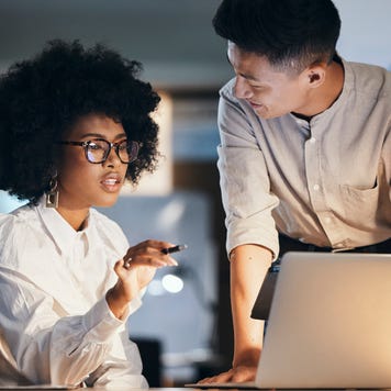 Black woman, businessman or laptop in night office for digital marketing strategy, brand logo design or website ux planning. Talking creative designer, workers or employees working late on technology