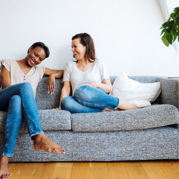 Friends laughing on the couch