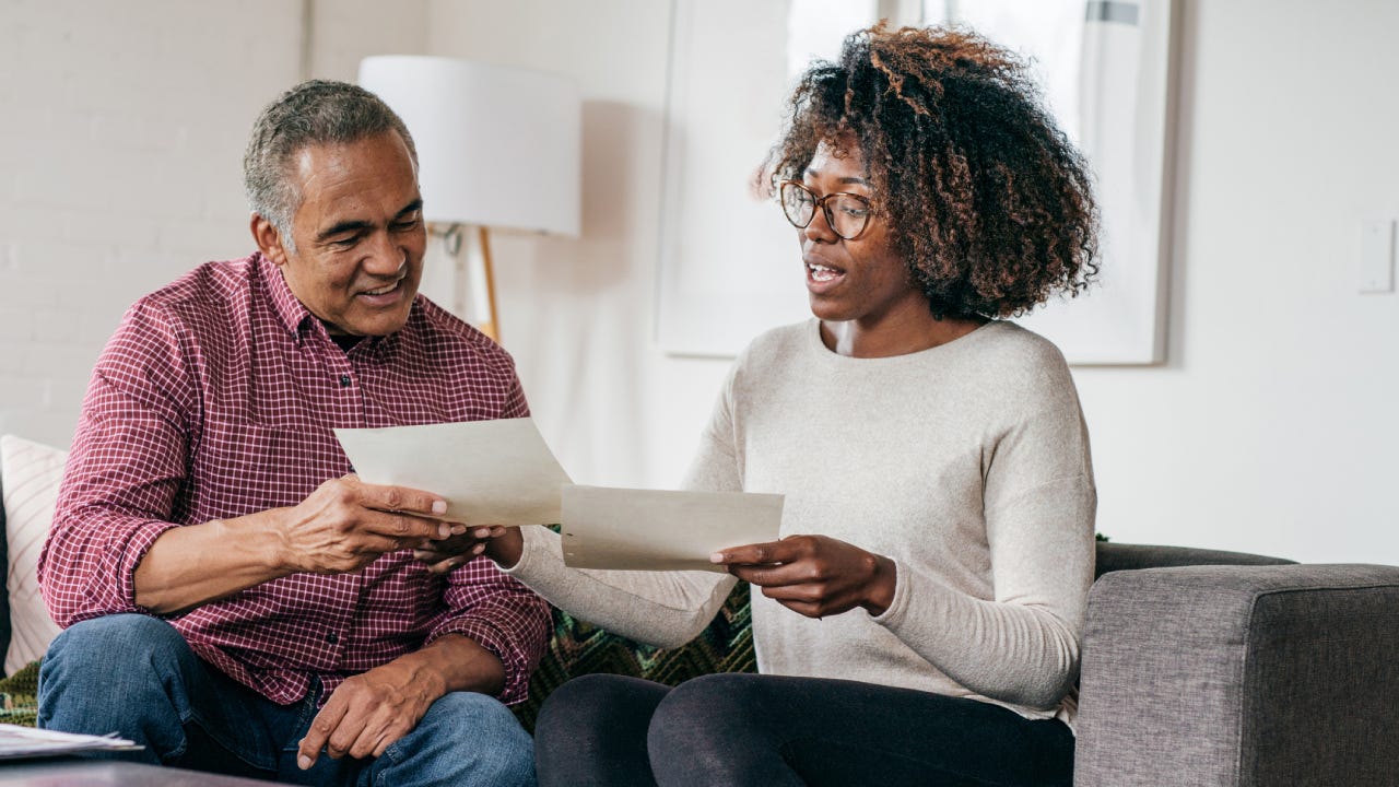 Senior African-American man receiving a home consultation from an African-American woman.
