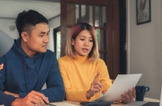 Young Asian couple looking at tax paperwork together