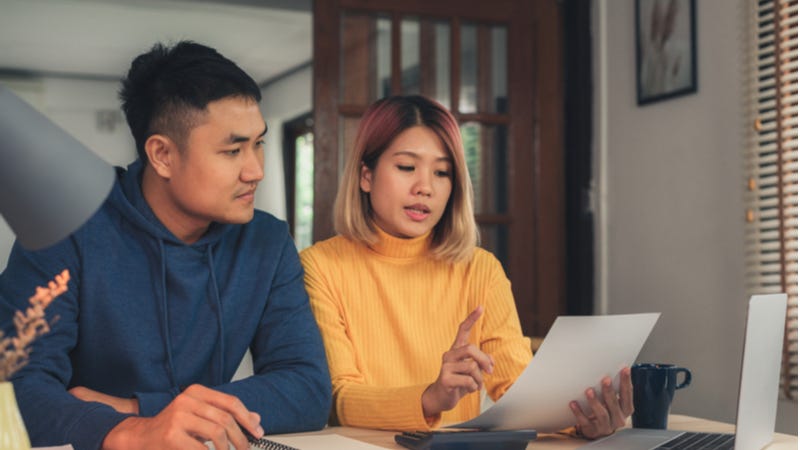 Young Asian couple looking at tax paperwork together