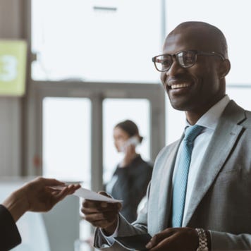 Young businessman purchases plane ticket at airport
