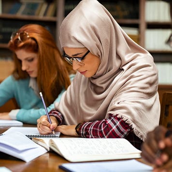 two young persons studying at a library