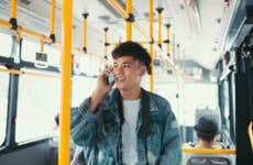 Man talking on phone while riding city bus