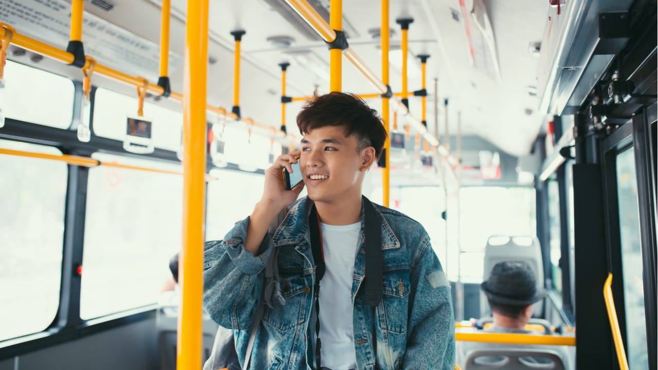 Man talking on phone while riding city bus