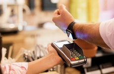person using watch to make payment at checkout