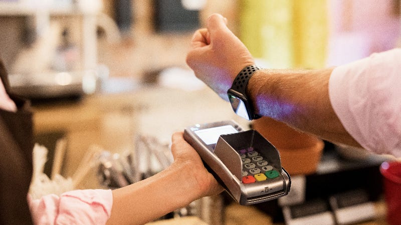 person using watch to make payment at checkout