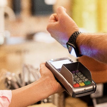 person using watch to make payment at checkout