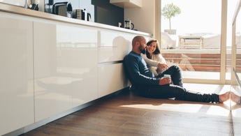 Couple sitting on floor of new home.