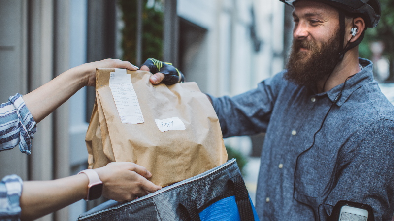 a bearded man delivery a bag of food