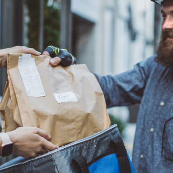 a bearded man delivery a bag of food