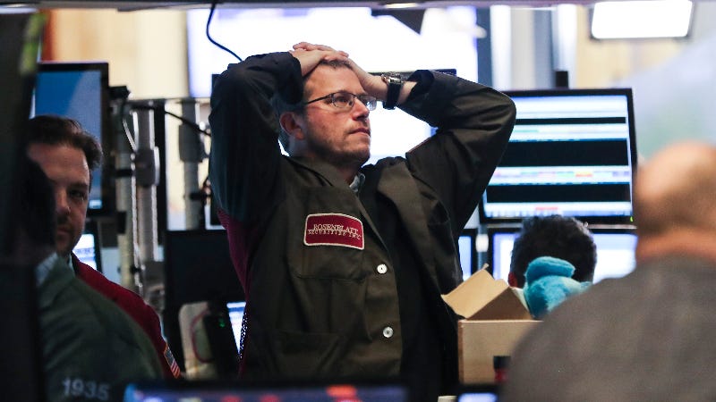 An exasperated stock trader holds his hands on his head