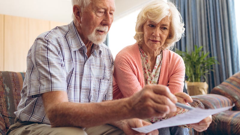An older couple gestures to a financial contract