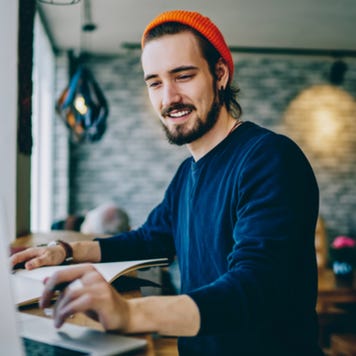 Young man working on laptop in trendy cafe