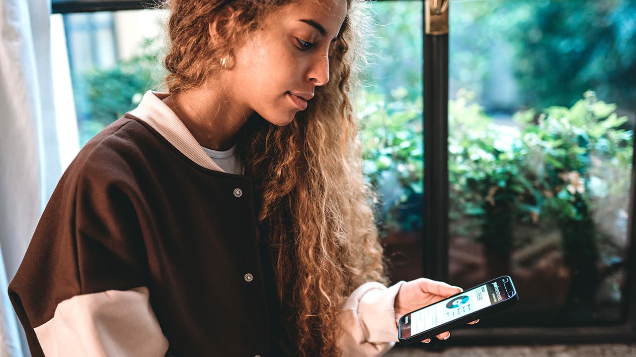 young woman checking her banking account on her phone