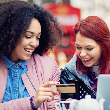 Two girlfriends are shopping online in the cafeteria