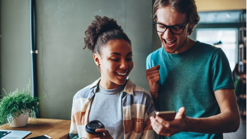 Young couple look at good news on smartphone