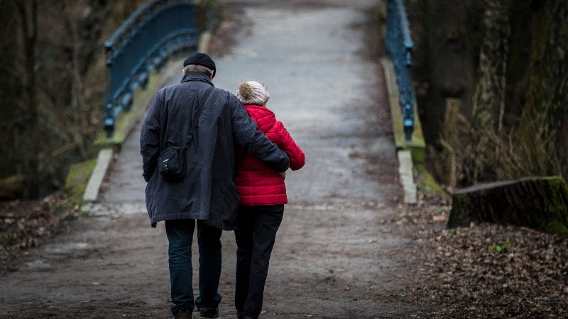 An older couple walks toward a bridge