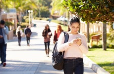 Student walking through college campus.