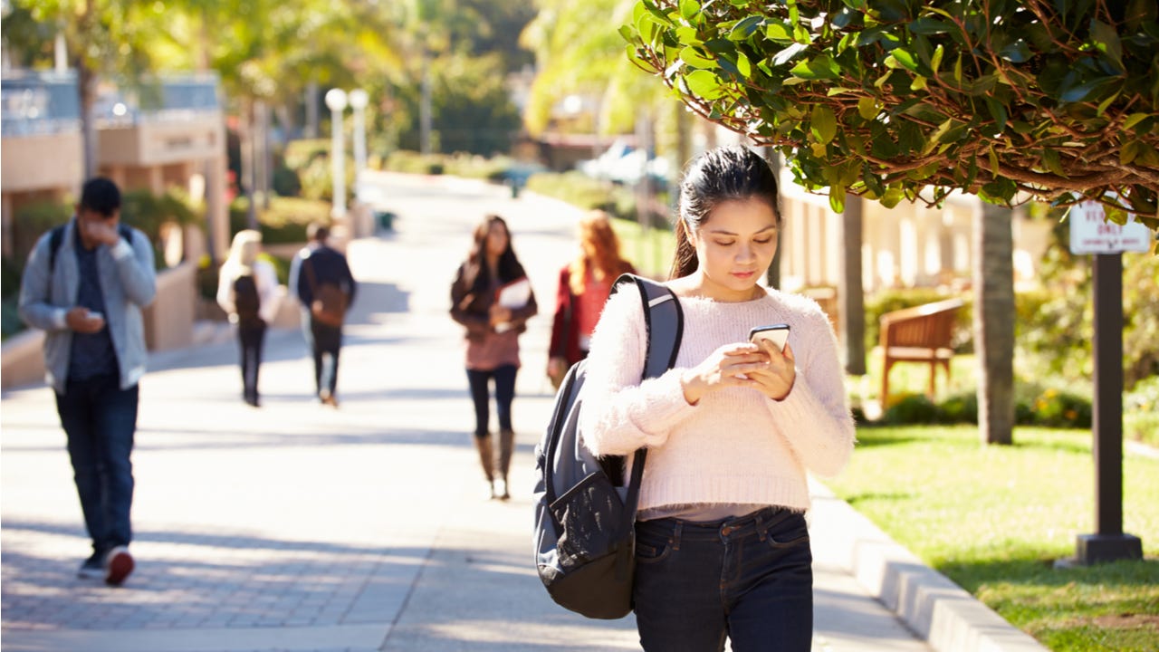 Student walking through college campus.