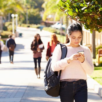 Student walking through college campus.