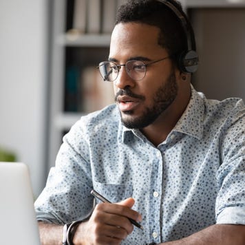 man sitting at desk in front of open laptop