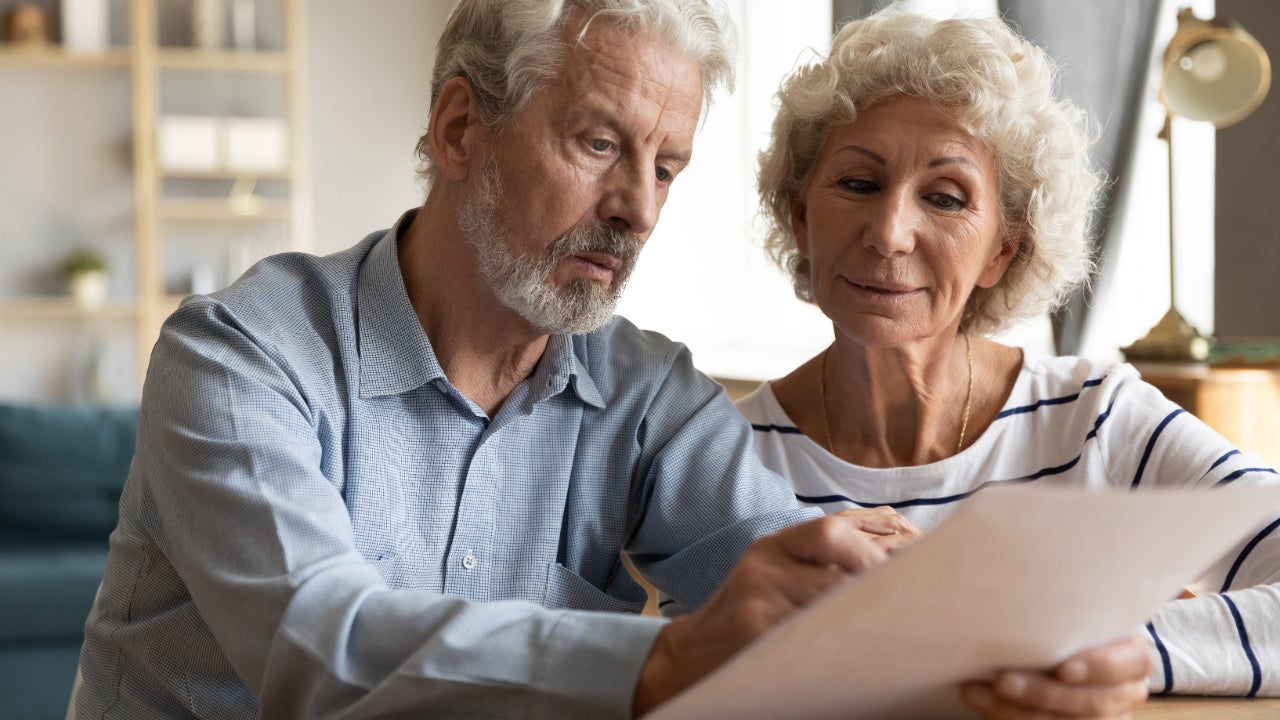 An older white couple discusses a document