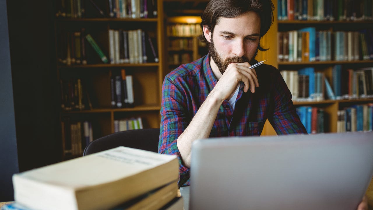 A young man researches in the library.