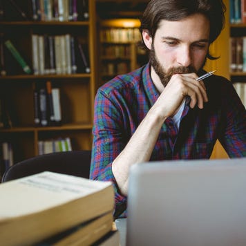 A young man researches in the library.