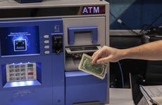 A man gets money from an ATM.