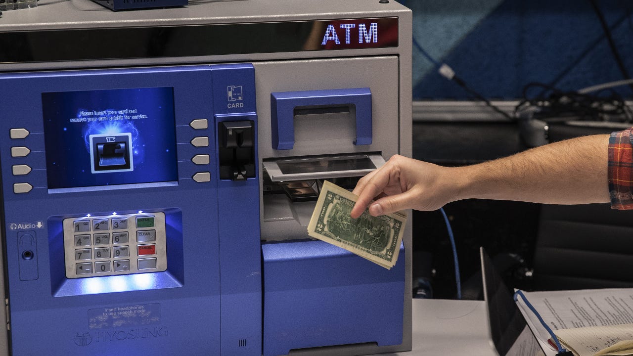 A man gets money from an ATM.