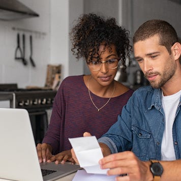 couple sitting at table going over receipts together