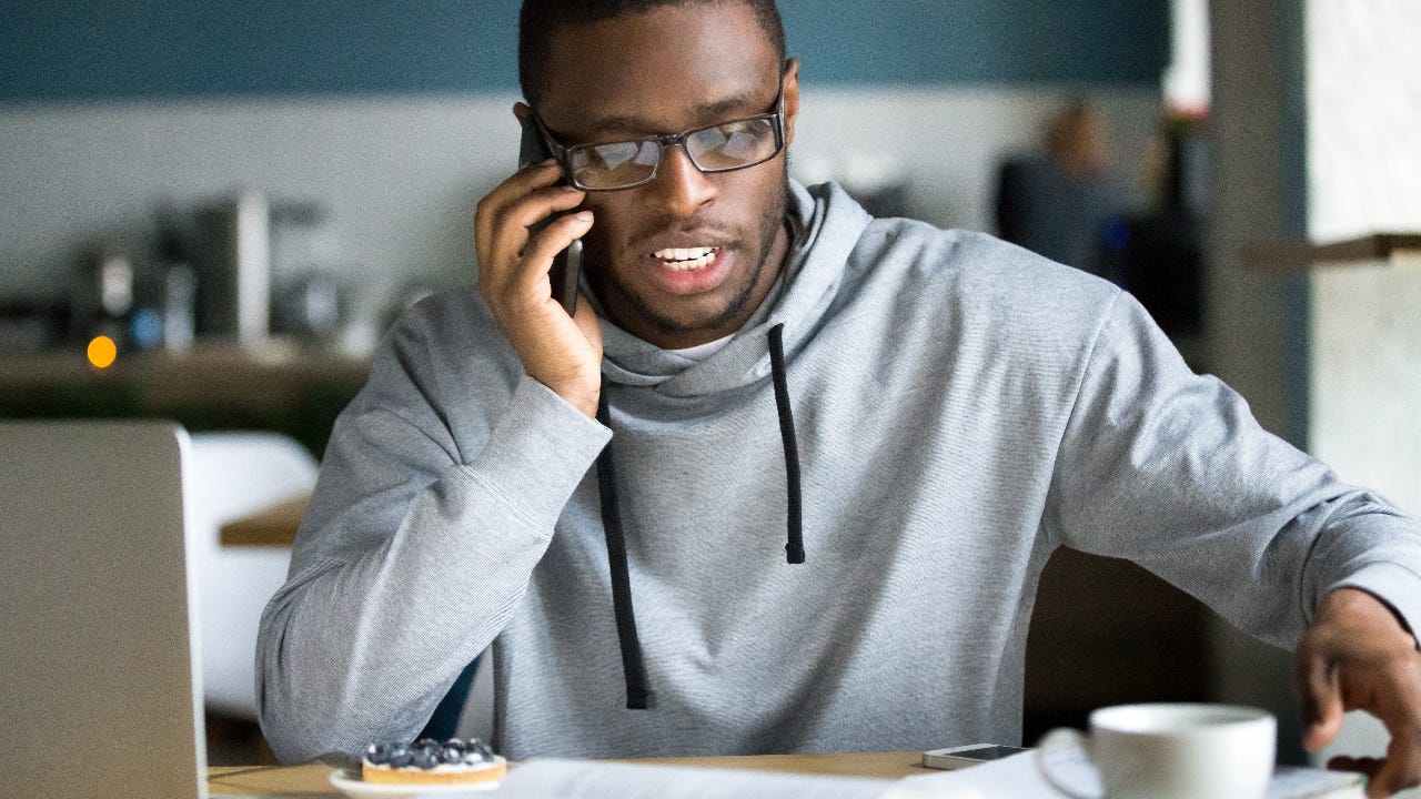 A man at home makes a phone call.