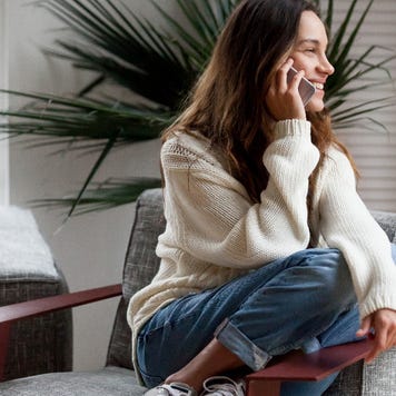 young woman at home talking on cell phone