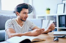 man sitting at home reviewing receipts