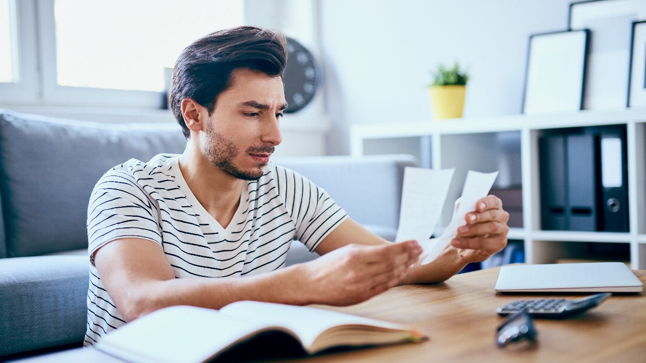 man sitting at home reviewing receipts