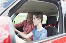 Father teaching son driving a car