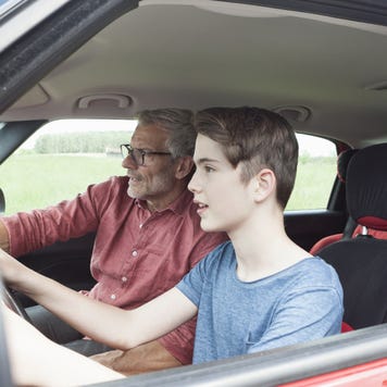 Father teaching son driving a car