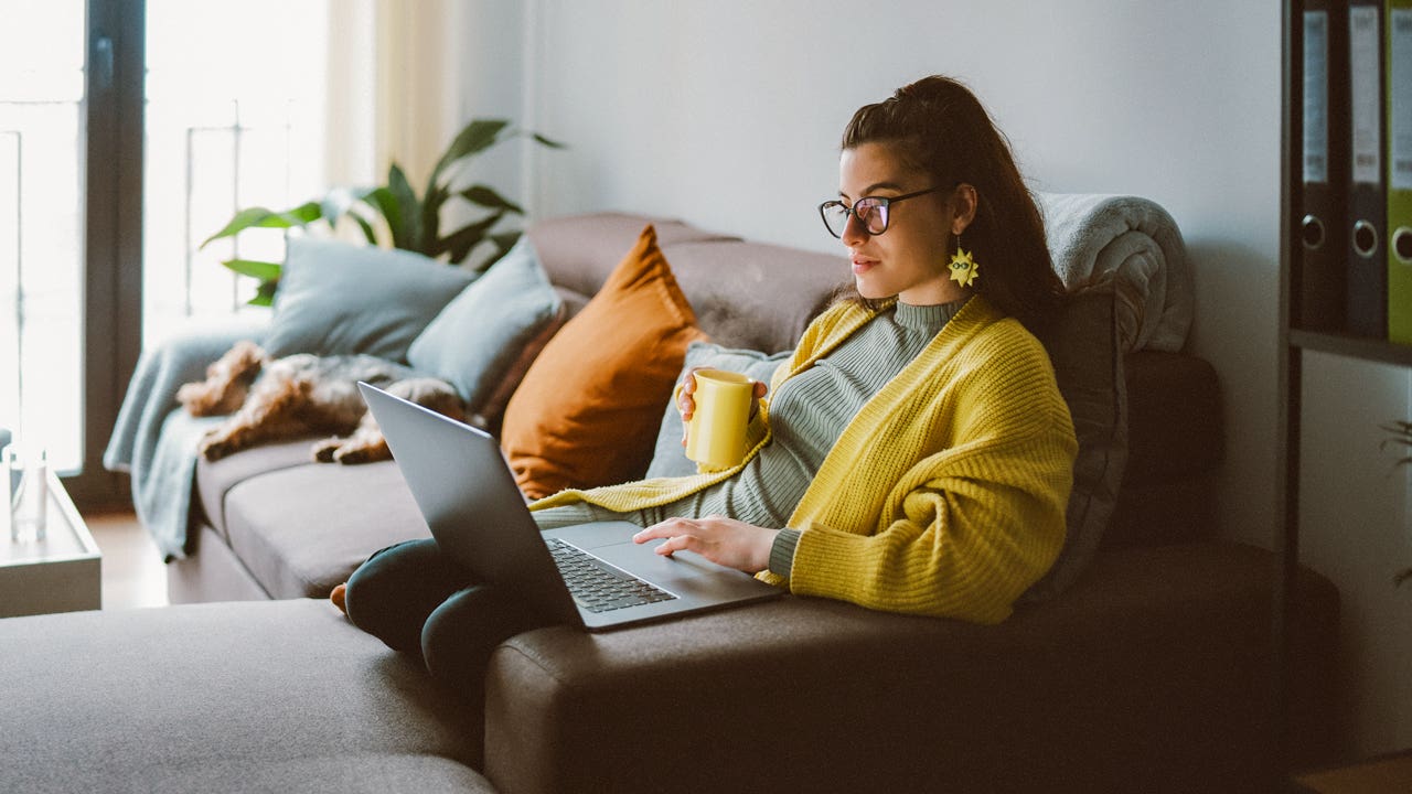 person laying on cash with laptop on lap