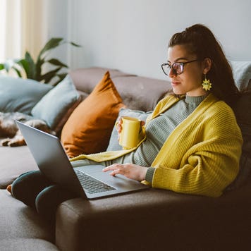 person laying on cash with laptop on lap