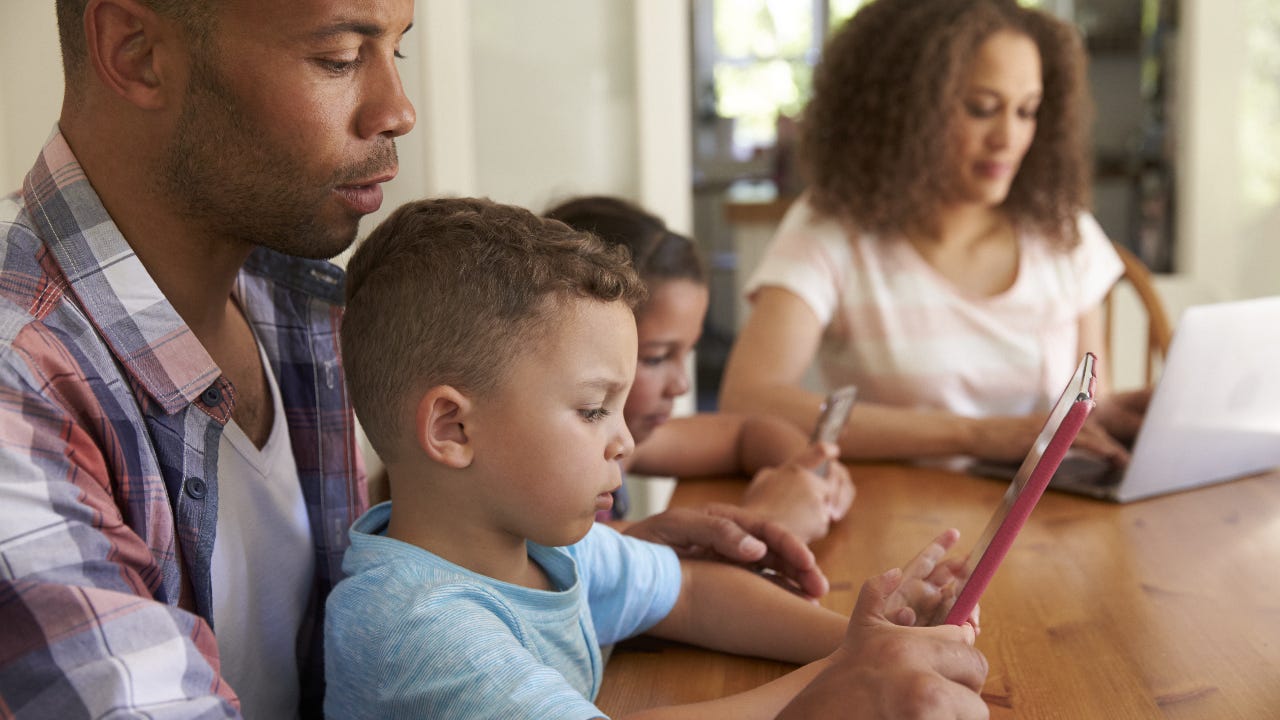 A family sits together at a kitchen table.