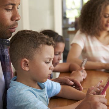 A family sits together at a kitchen table.