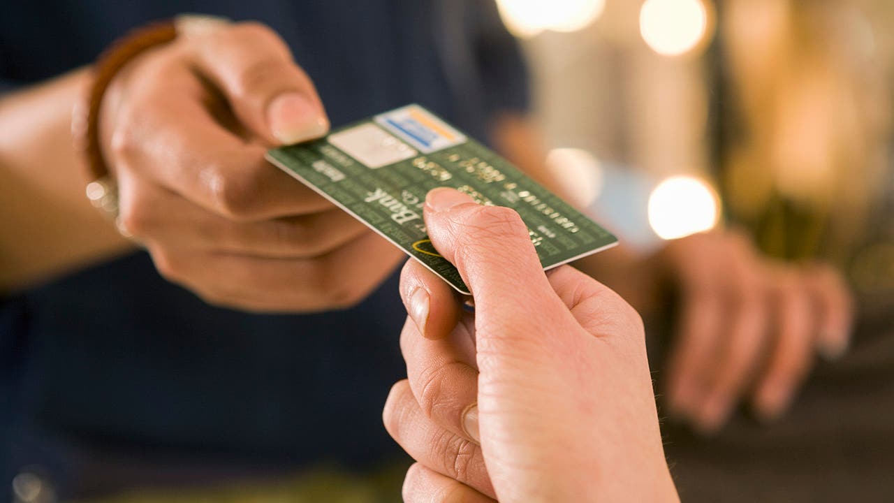 Close-up shot of two people exchanging a credit card