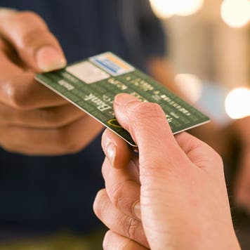 Close-up shot of two people exchanging a credit card